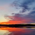 visual image of a sunset over the lake